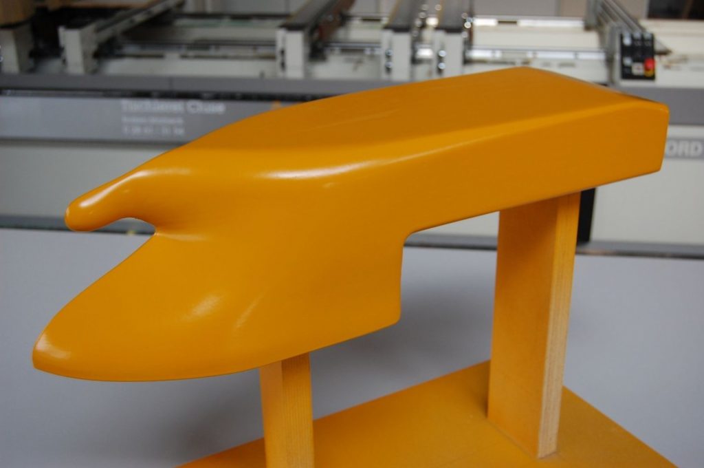 CNC-gefrästes gelb lackiertes Designmodell auf Holzbeinen – Formenbau der Tischlerei Cluse