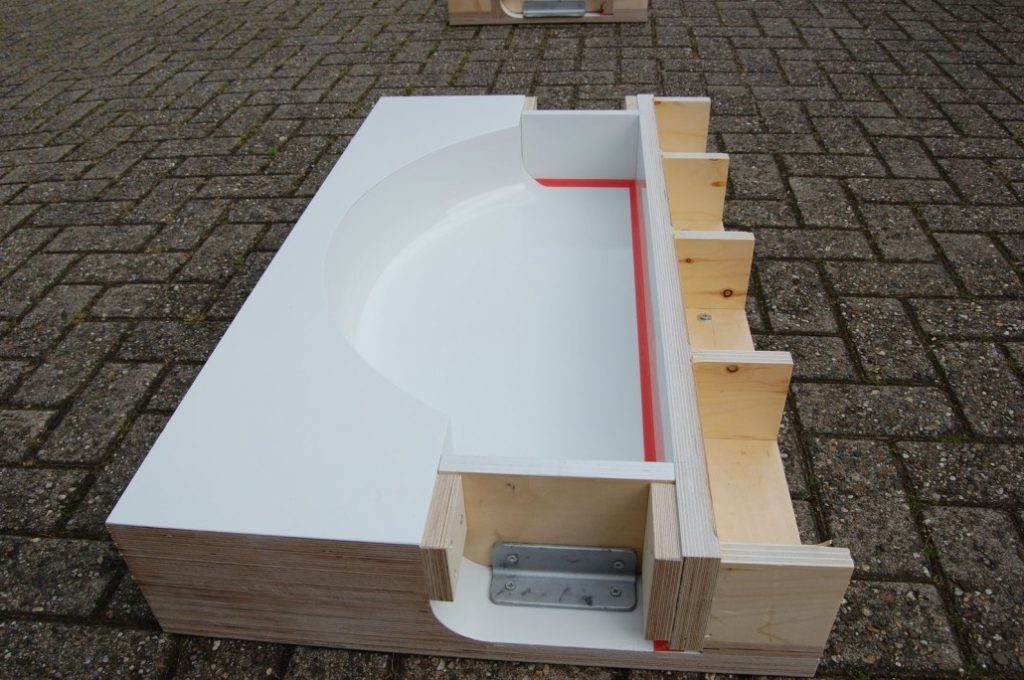 Holzschalung mit weißer Kunststoffeinlage und geschwungener Innenkontur – Formenbau der Tischlerei Cluse