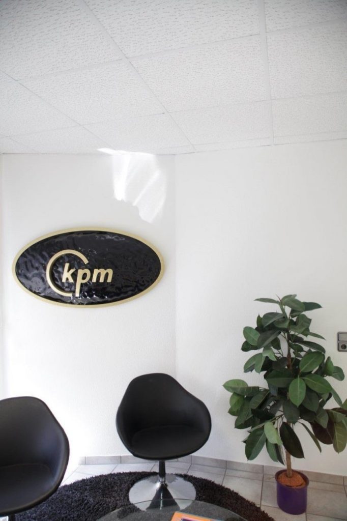 CNC-gefrästes Firmenlogo „kpm" als Wandschild – individuelle Beschilderung von Tischlerei Cluse