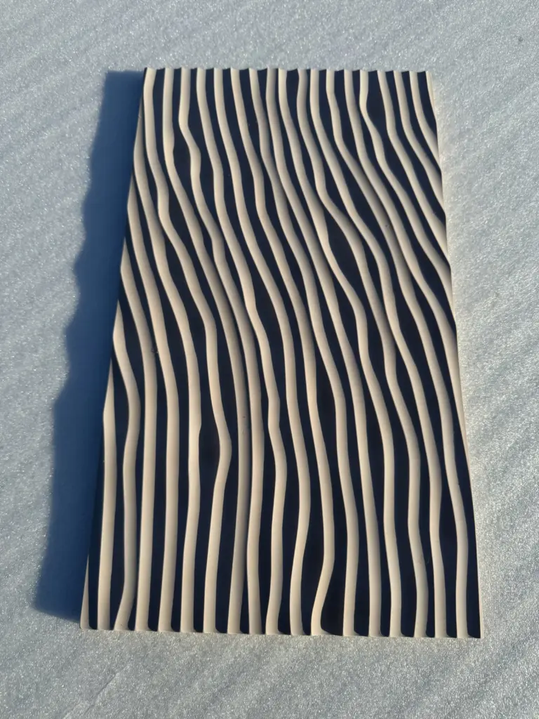 CNC-gefräste Designoberfläche mit wellenförmiger Rillenstruktur – 3D-Fräsarbeit der Tischlerei Cluse