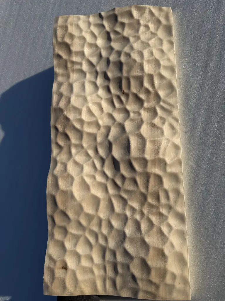 CNC-gefräste Designoberfläche mit organischer Wabenstruktur aus Holz – 3D-Fräsmuster der Tischlerei Cluse
