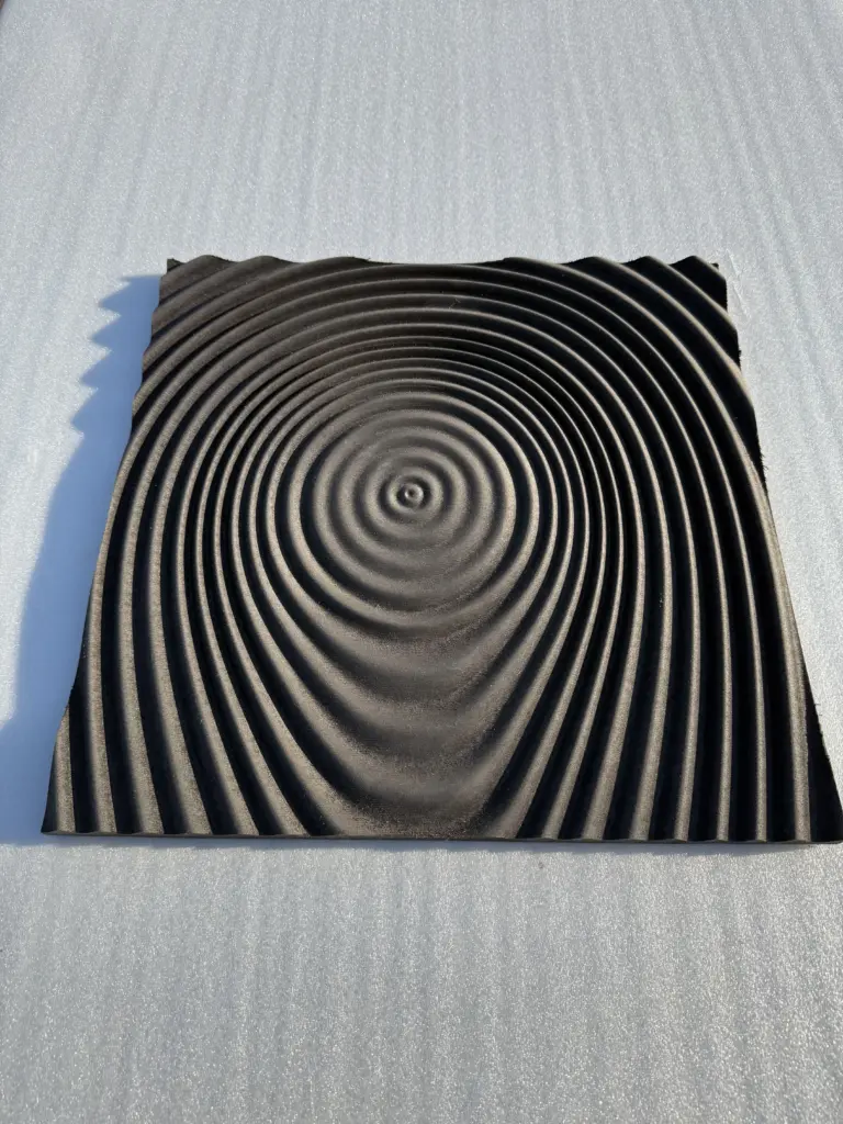 CNC-gefräste Designoberfläche mit konzentrischen Kreisrillen – dekoratives 3D-Fräsmuster der Tischlerei Cluse