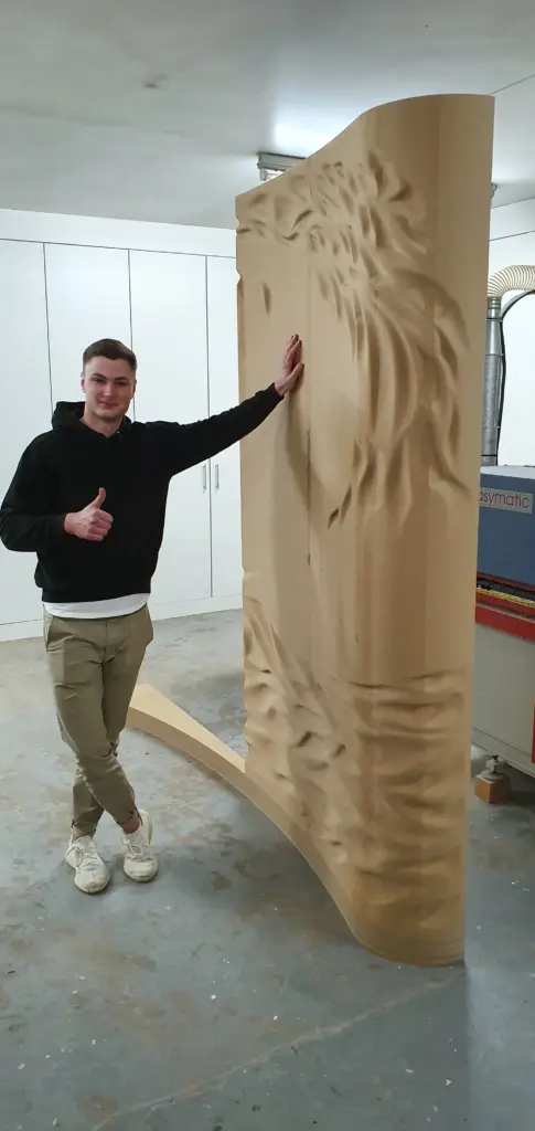 Mitarbeiter der Tischlerei Cluse neben großformatiger CNC-gefräster Wandverkleidung mit organischem Relief für den Yachtinnenausbau