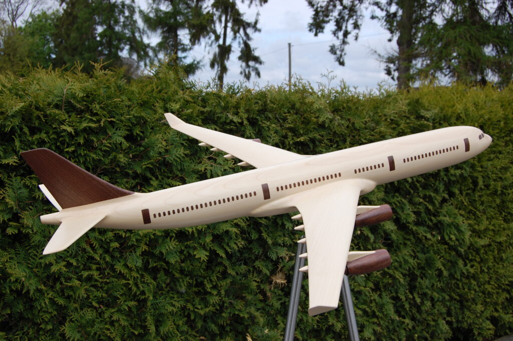 Flugzeug mit eingefrästen Fenstern und Türen aus Ahorn und Nussbaum ausgefräst und verleimt